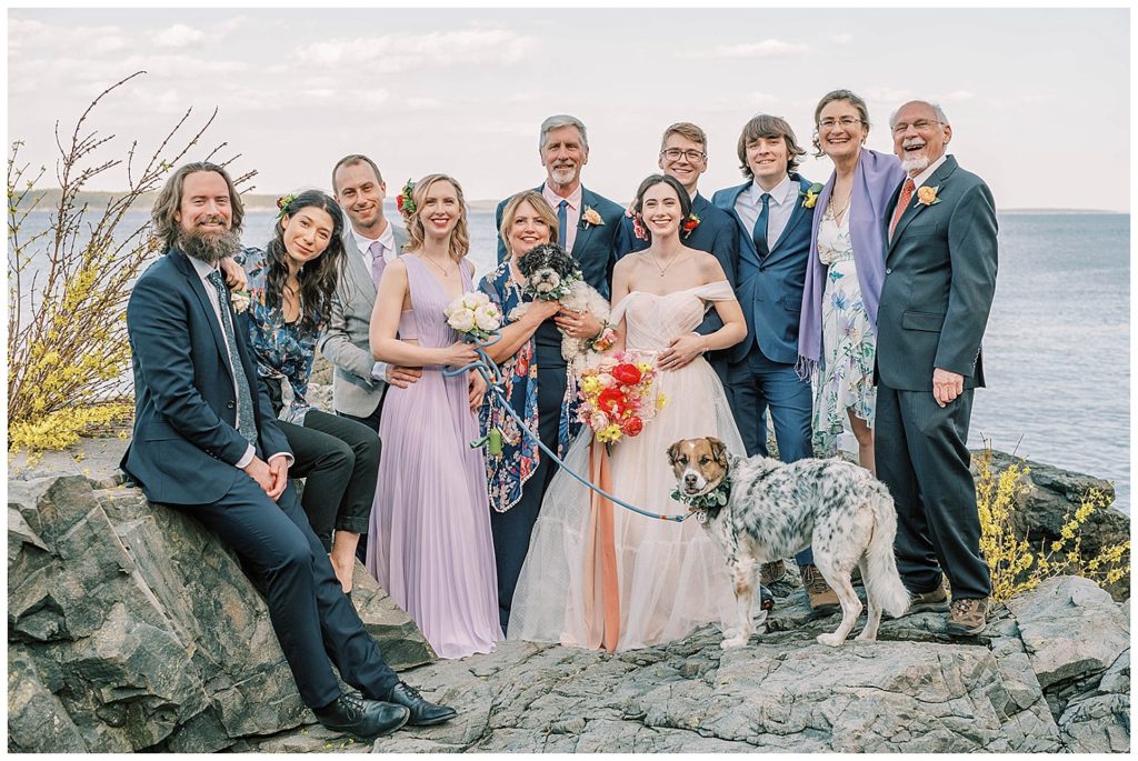 bride and groom posing with family at Maine elopement