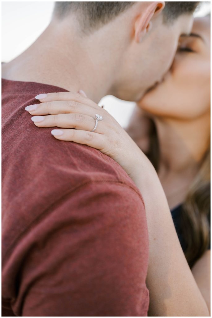 close up of engagement ring on man's shoulder