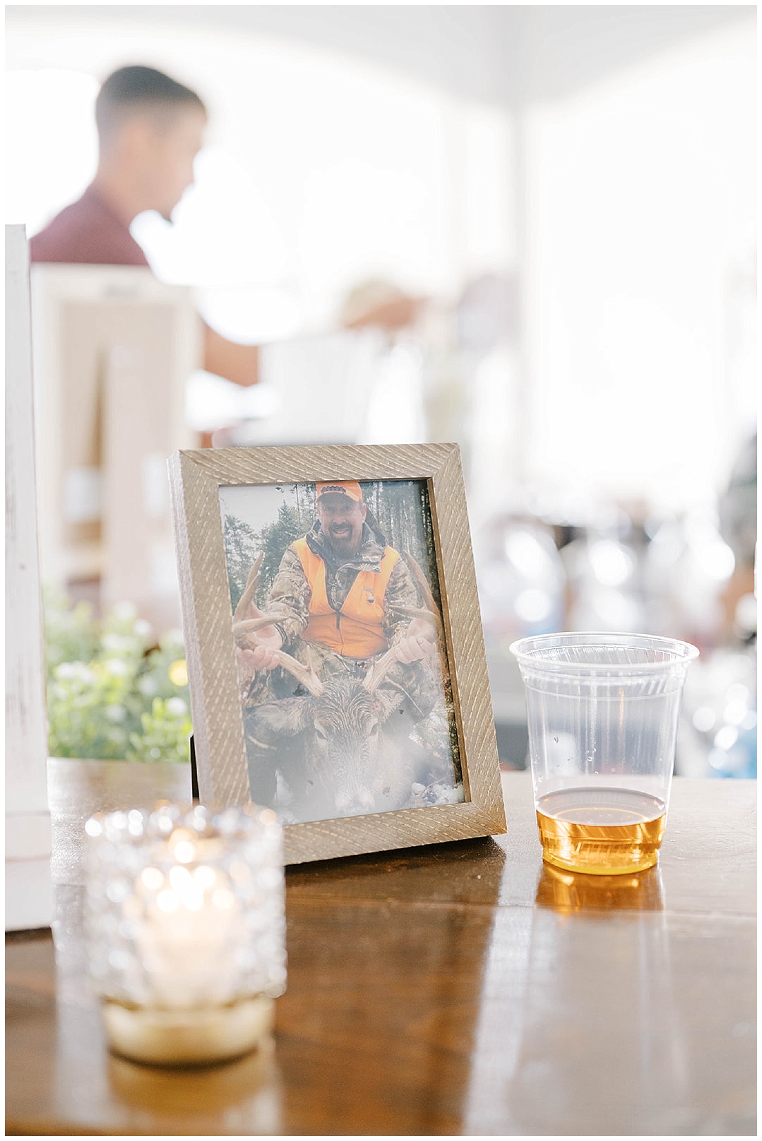 a shot of whiskey next to the framed photo of the bride's late dad