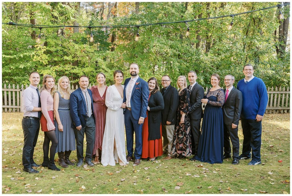 bride and groom posing with guests at reception in Maine