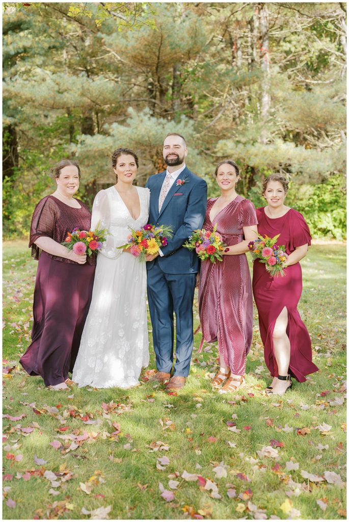bride and groom posing with bridesmaids before wedding in Maine