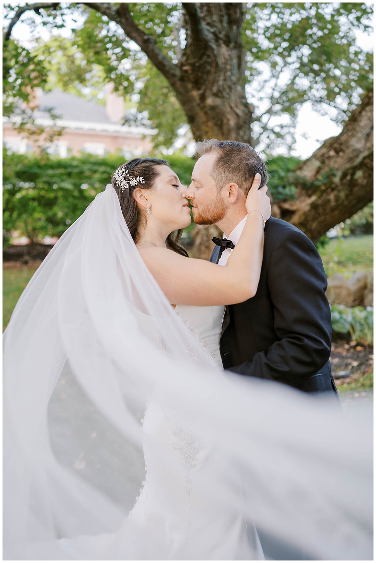 bride and groom kiss during portraits at wedding