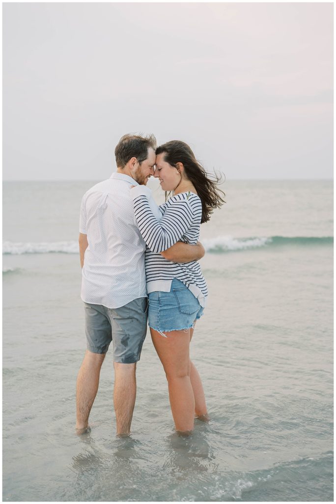couple standing in the water at beach engagement session