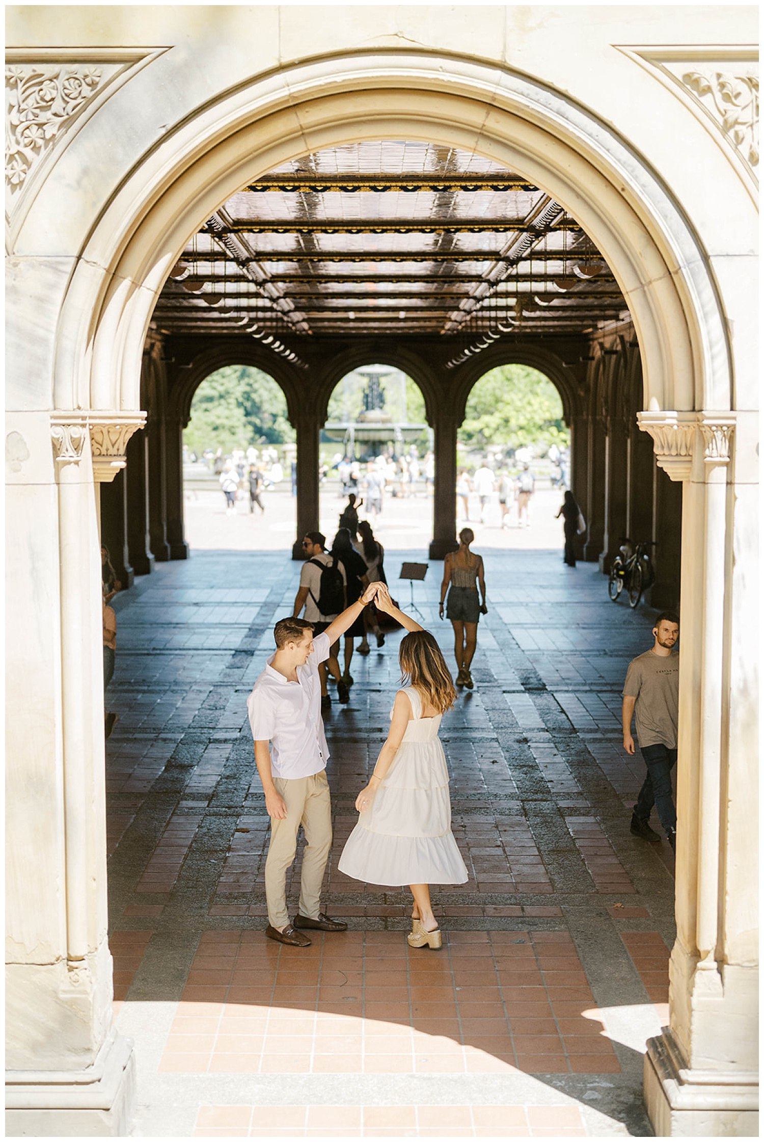 couple twirling underneath an arch at Central Park in New York
