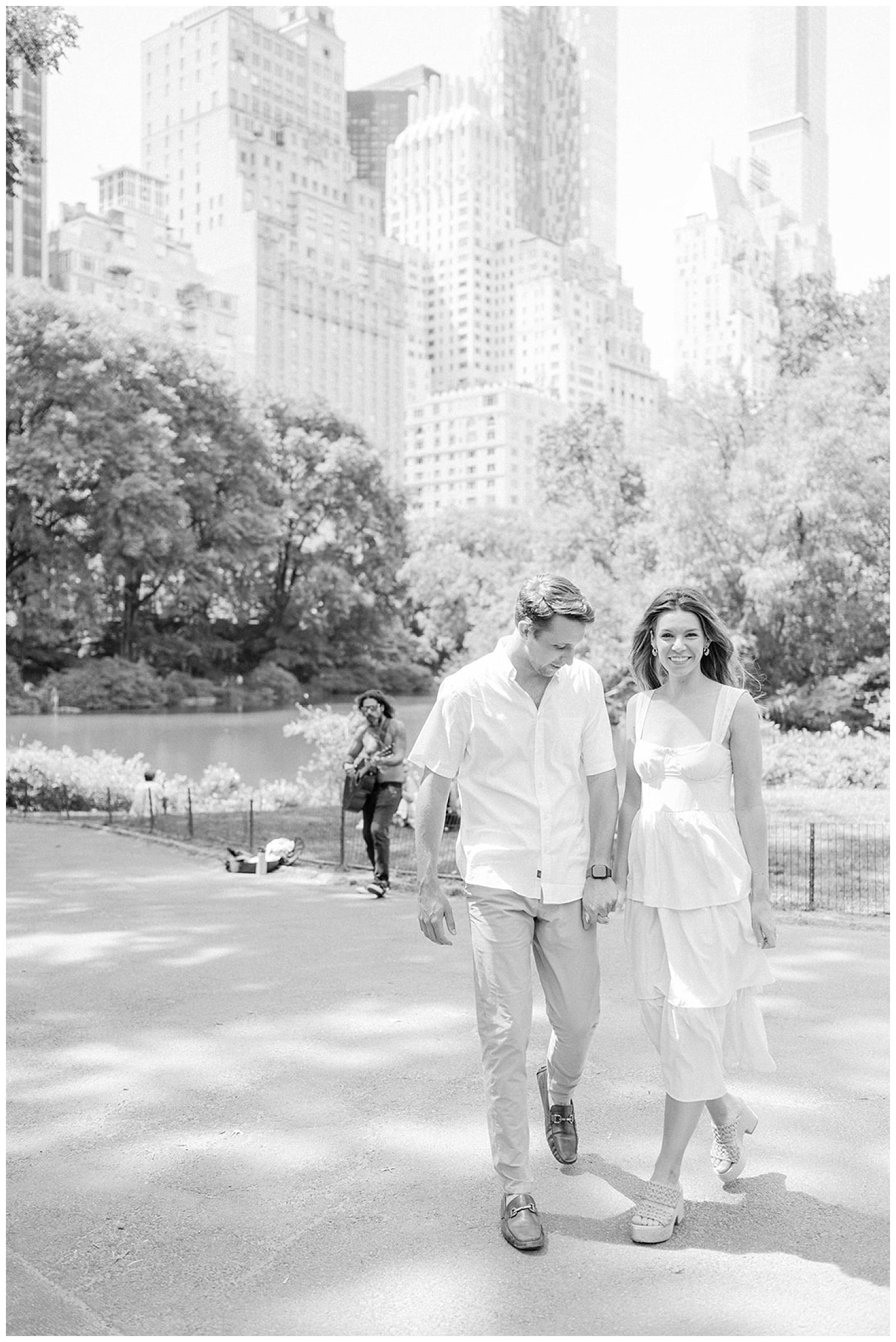 couple walking in Central Park with New York skyline in the background