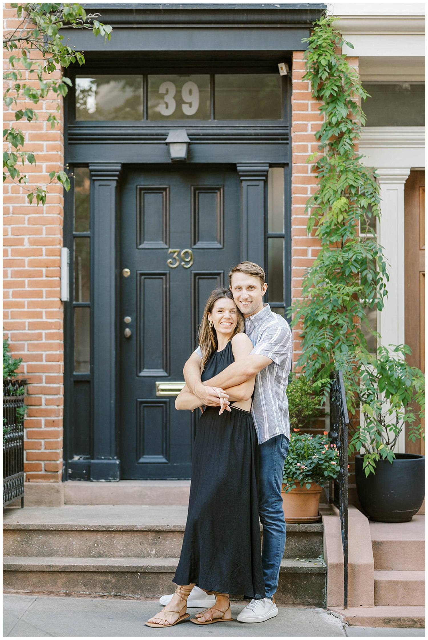 engaged couple hugging in front steps of a brownstone in New York City