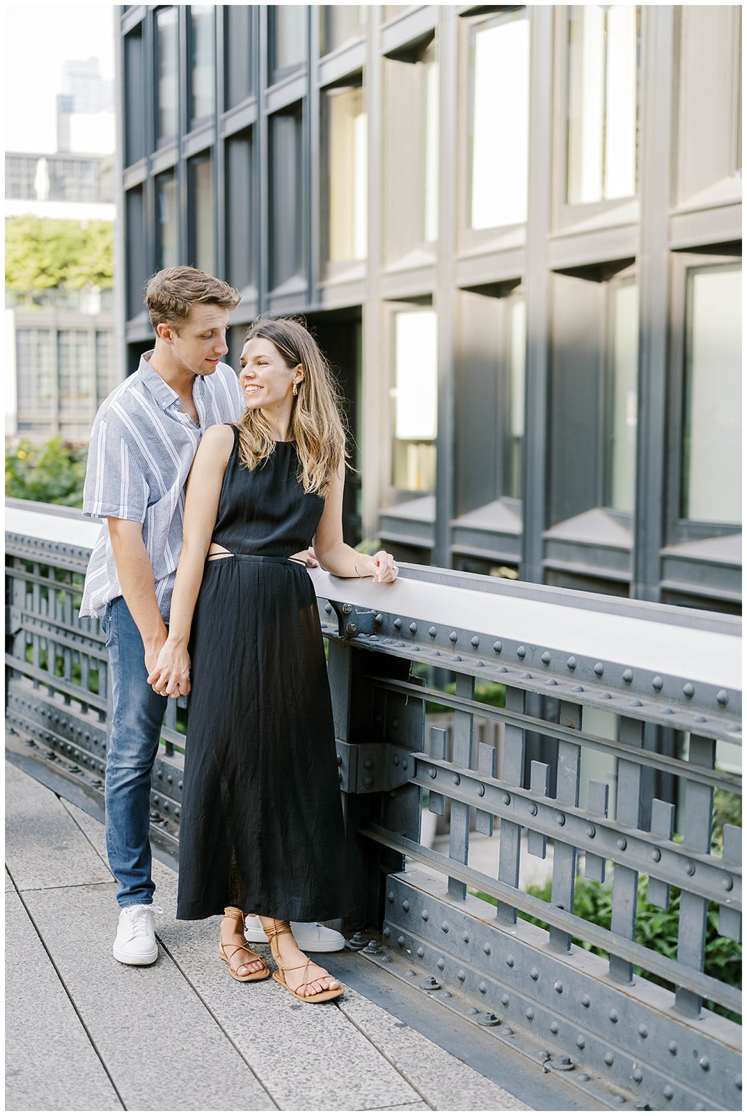 engaged couple standing on a bridge in New York City