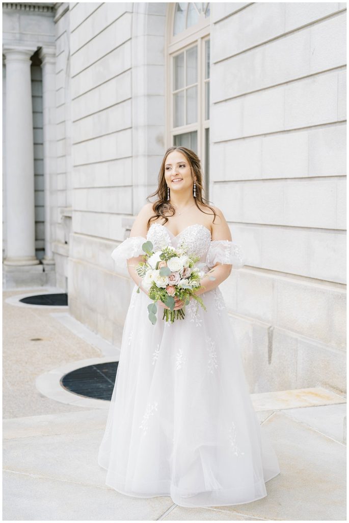 bride posing with bouquet outside Portland City Hall