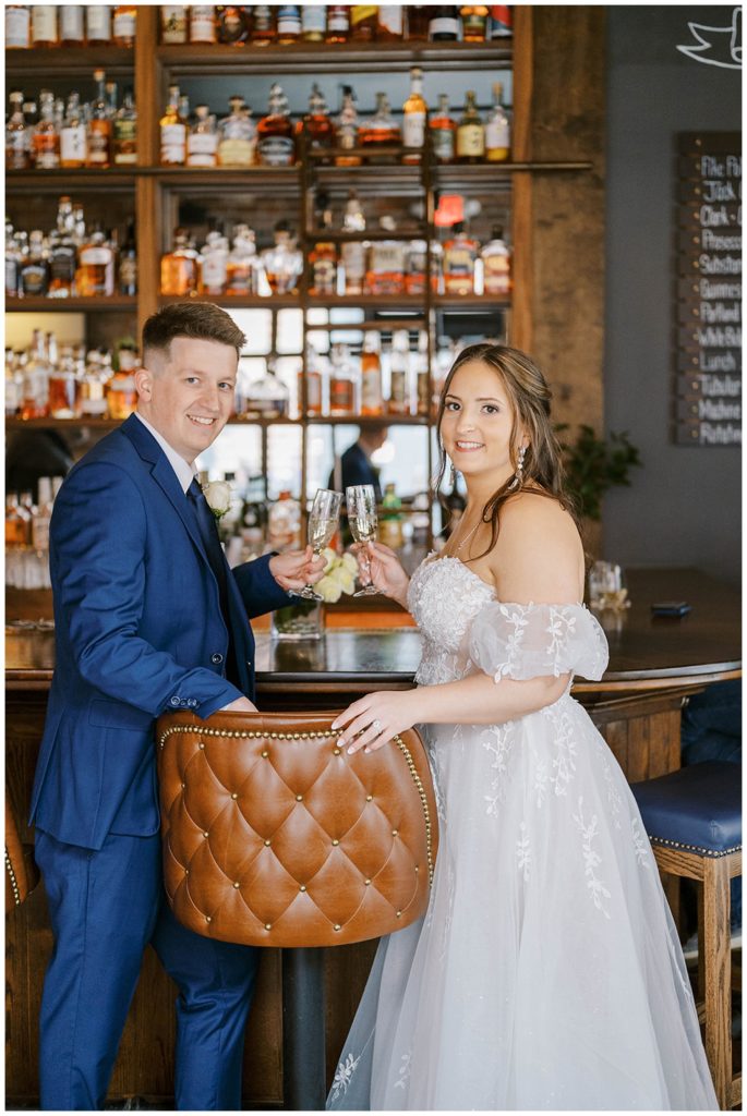 bride and groom toasting with champagne at bar in Portland Maine