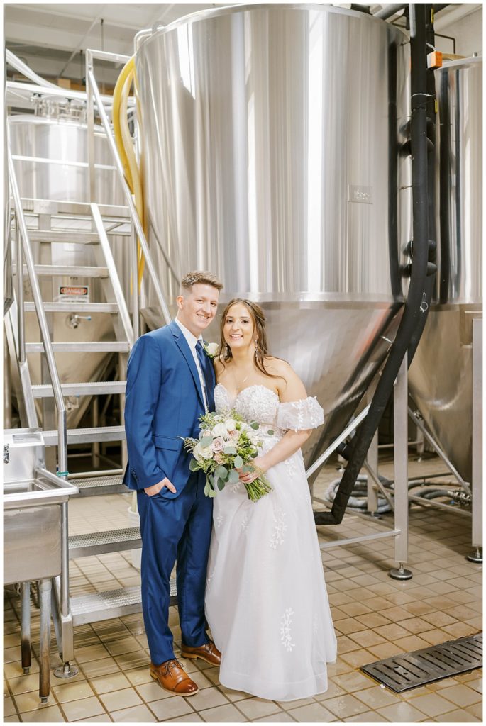bride and groom posing inside the beer brewing room