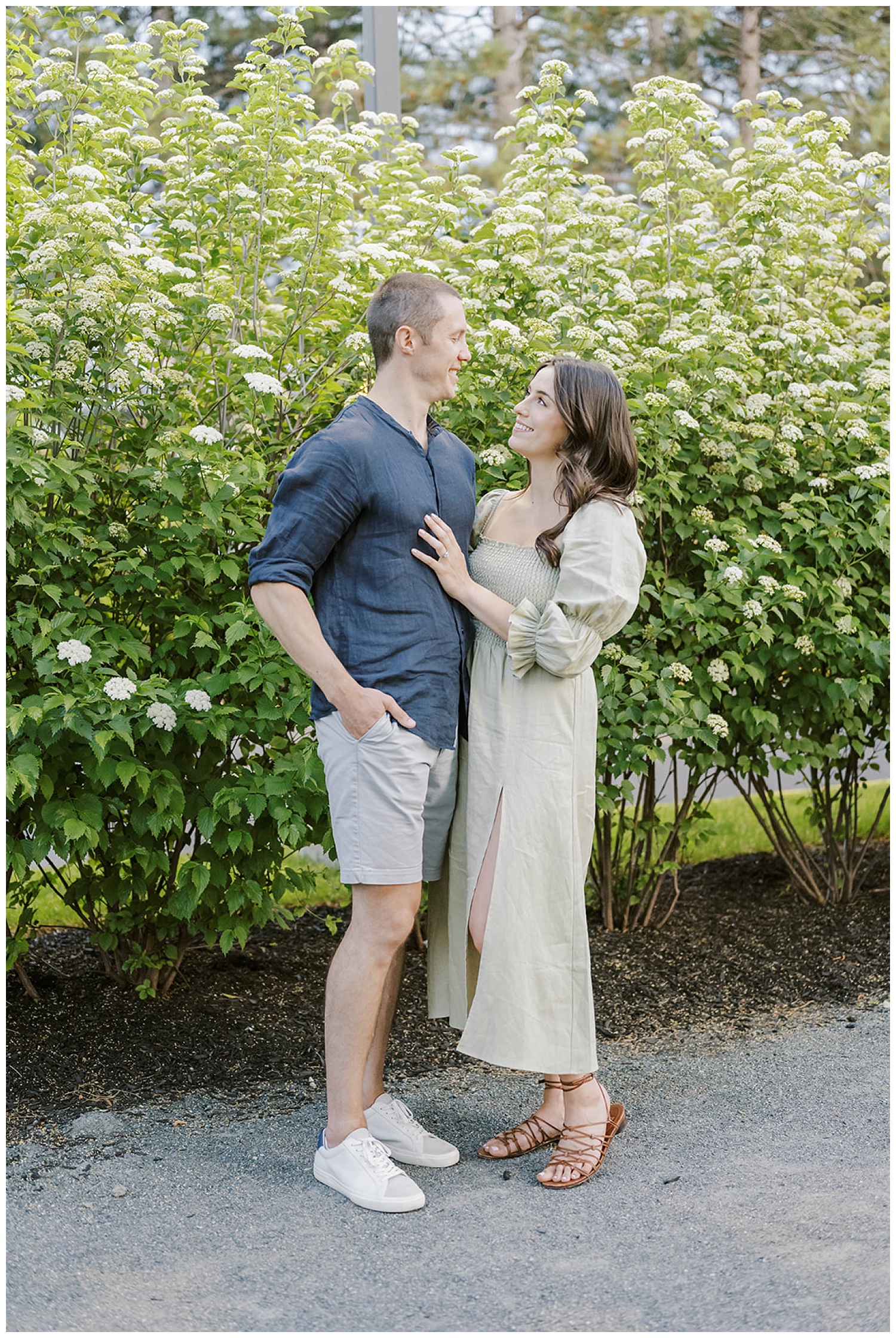 couple posing together in front of white flowers in Boston