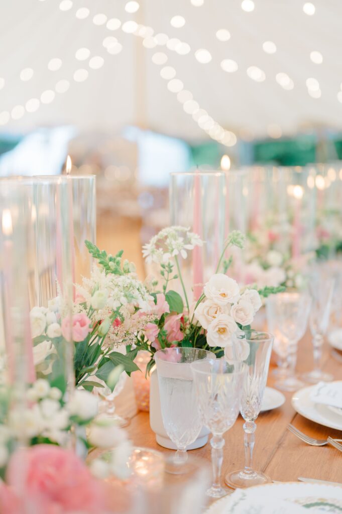 Close-up of wedding table decor with blush blooms and delicate candlelight.