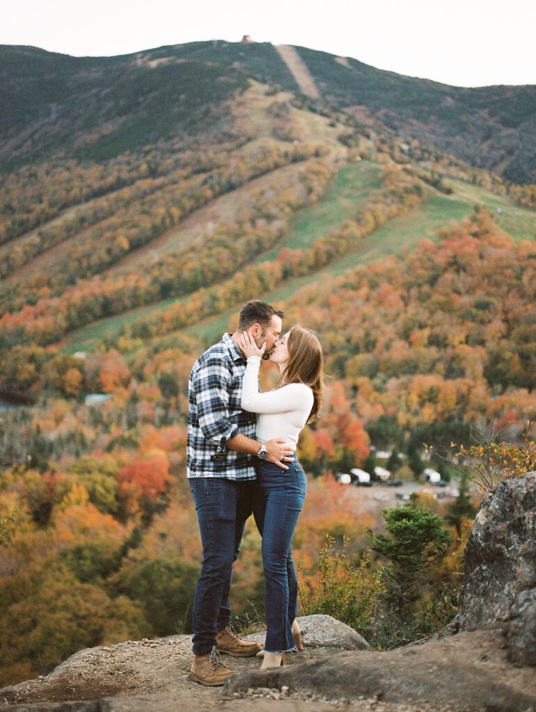 couple kiss on mountain during fall in New Engalnd