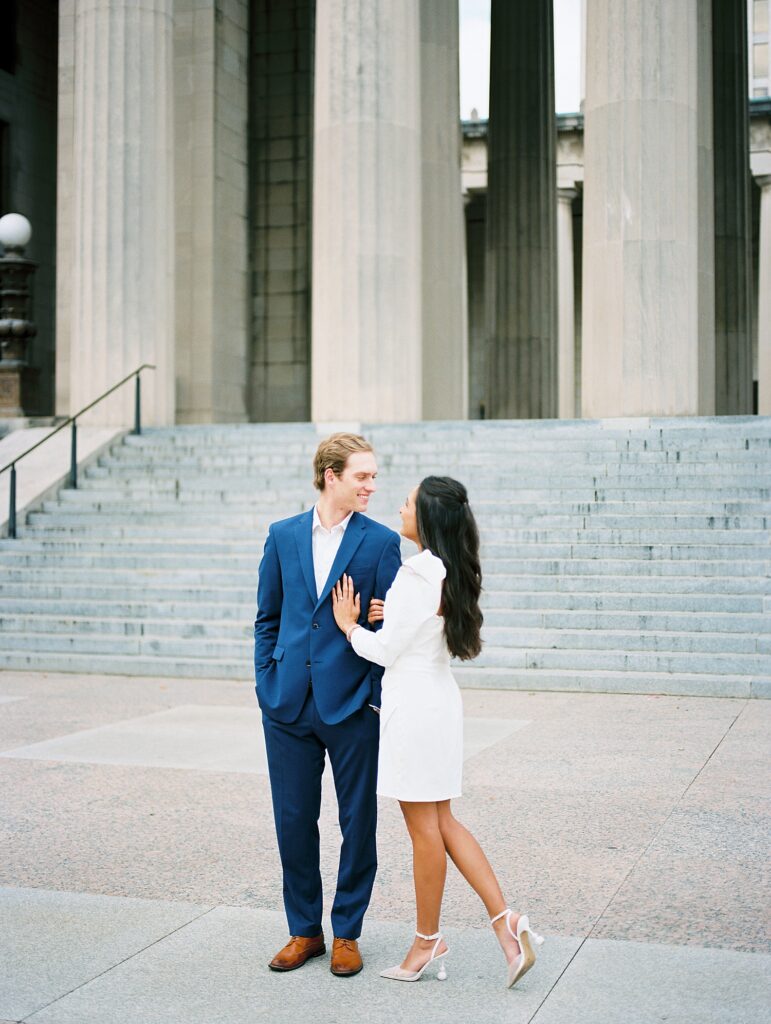 newly engaged couple pose in front of monument 