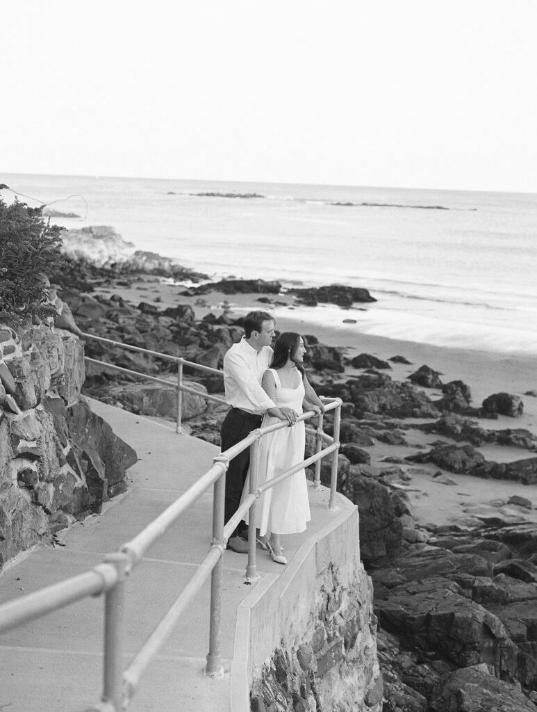 couple standing on New England coast line staring out into the water