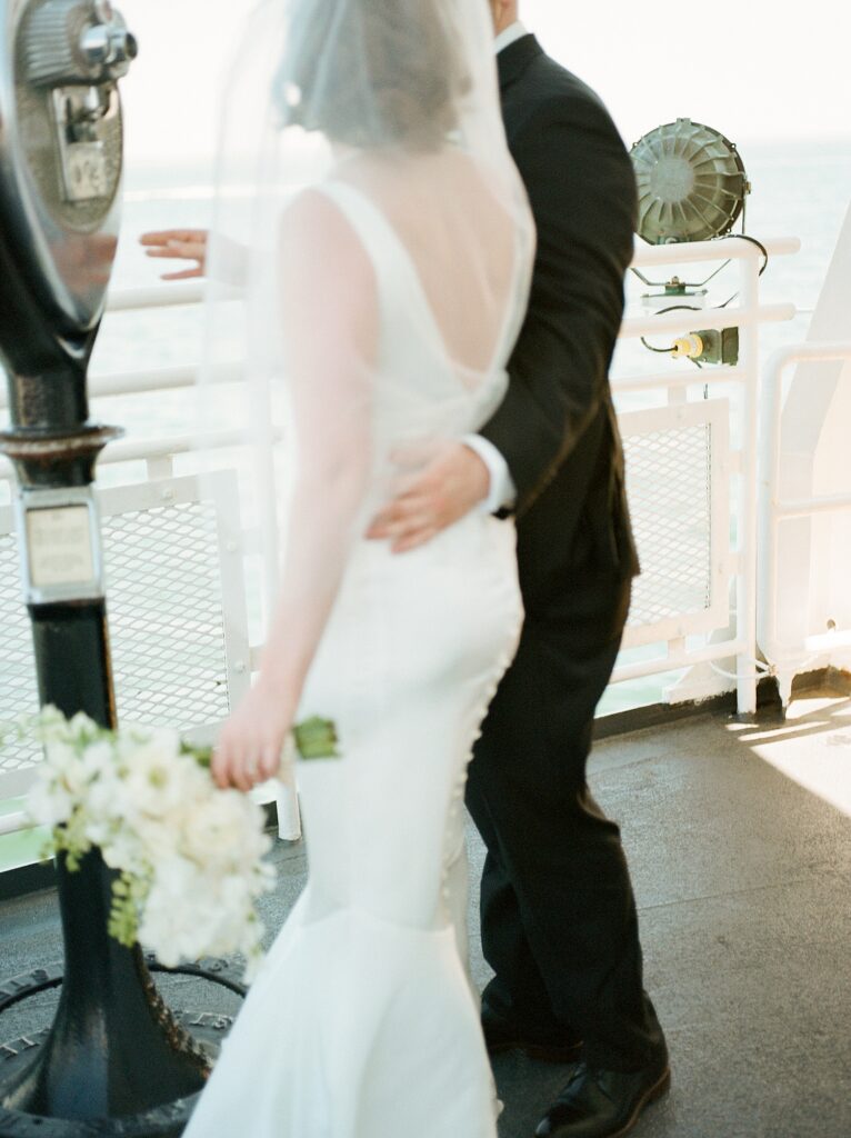 groom leads bride by the small of her back through reception 