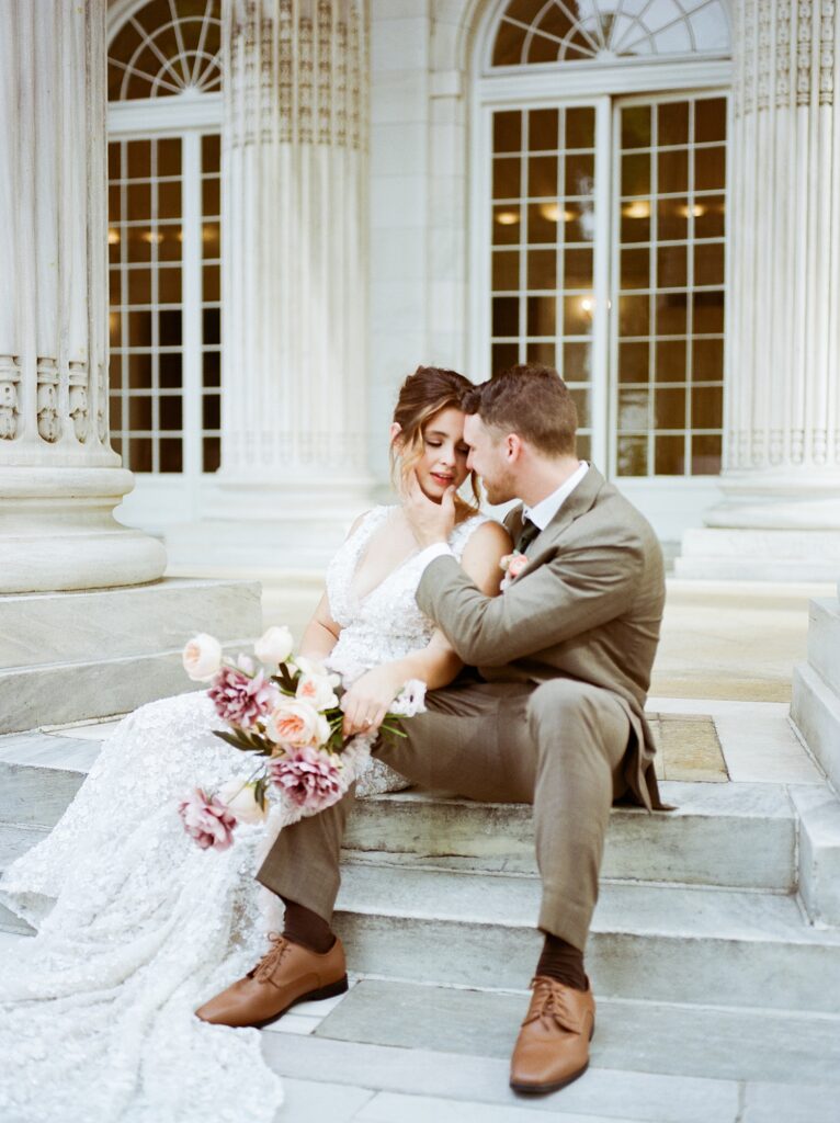 couple sit together on the DAR stairs during their wedding day