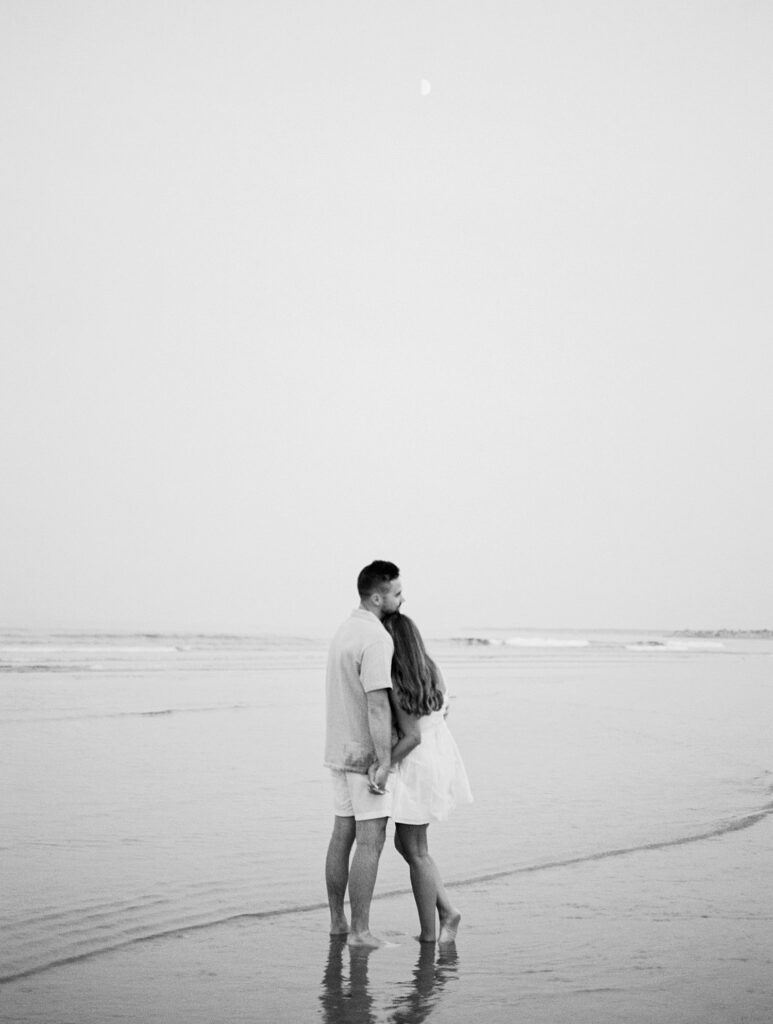 couple stand close while at the beach