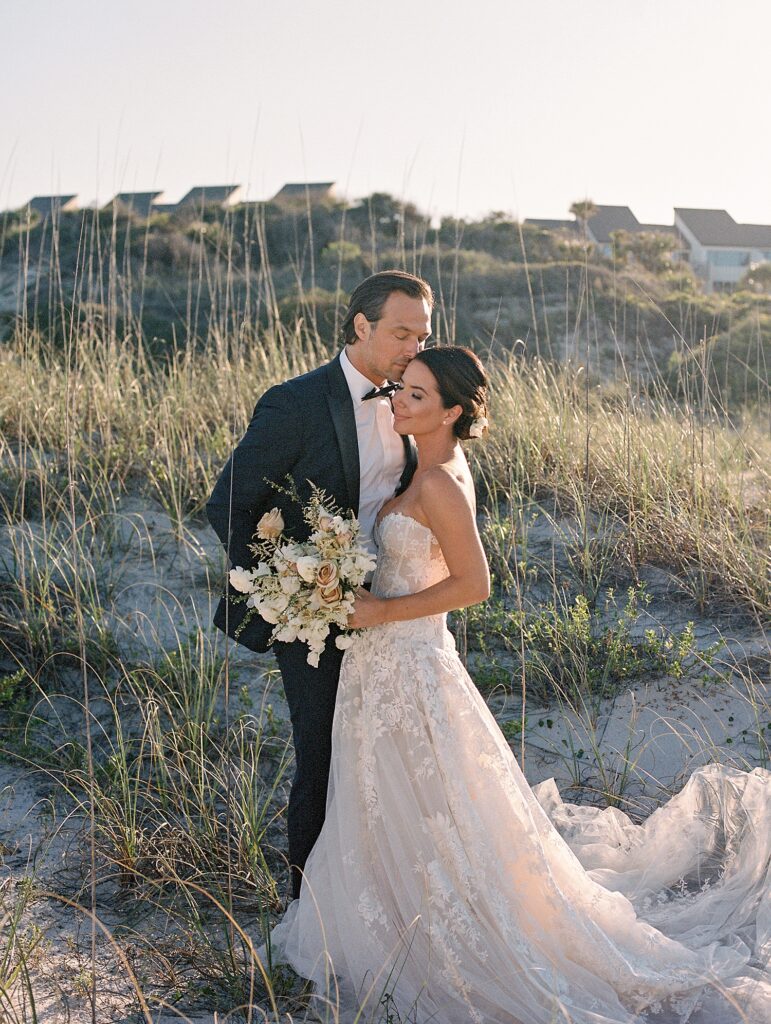 newlyweds kiss in the dunes in ameila island beach