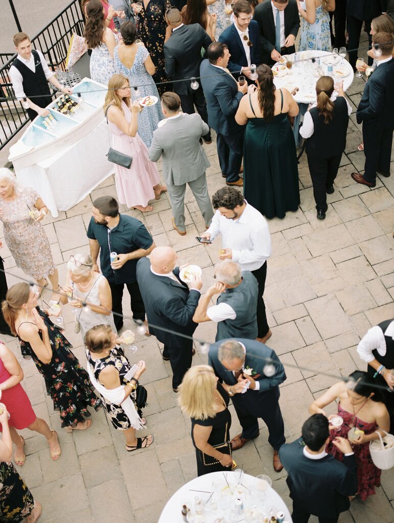 guests mingle on brick patio during wedding cocktail hour