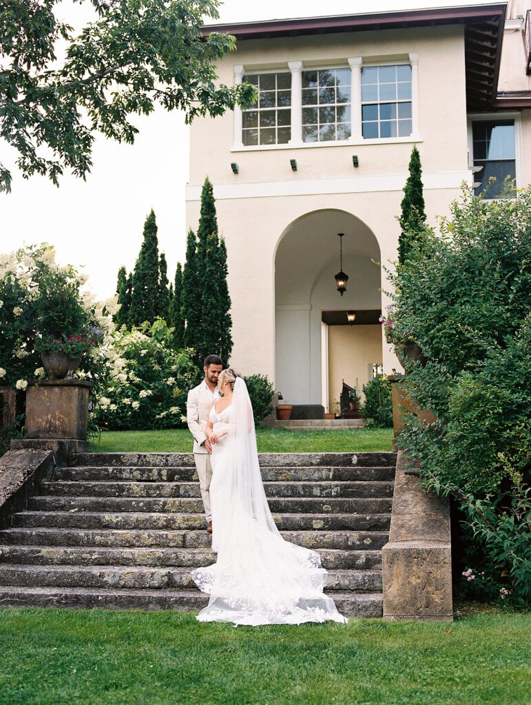 couple pose on the stairs of their Italian Villa wedding venue