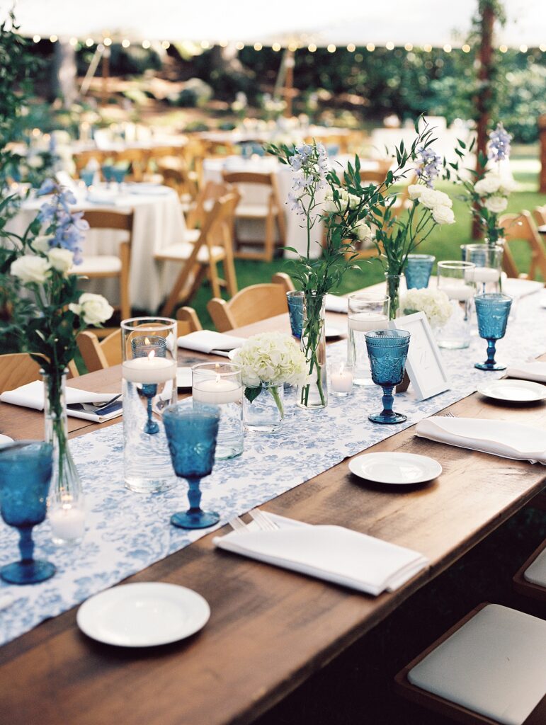 farmtable set with a blue and white toile runner and blue goblets