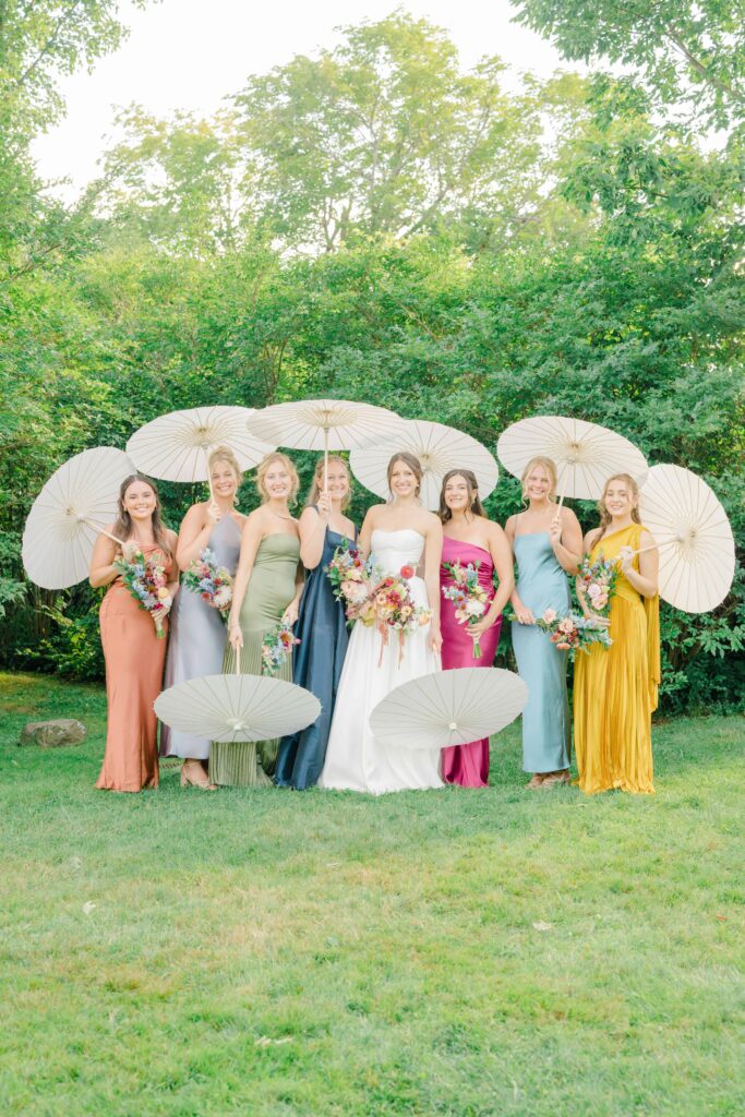 Bridesmaids in vibrant dresses laughing together before the ceremony at Aldworth Manor