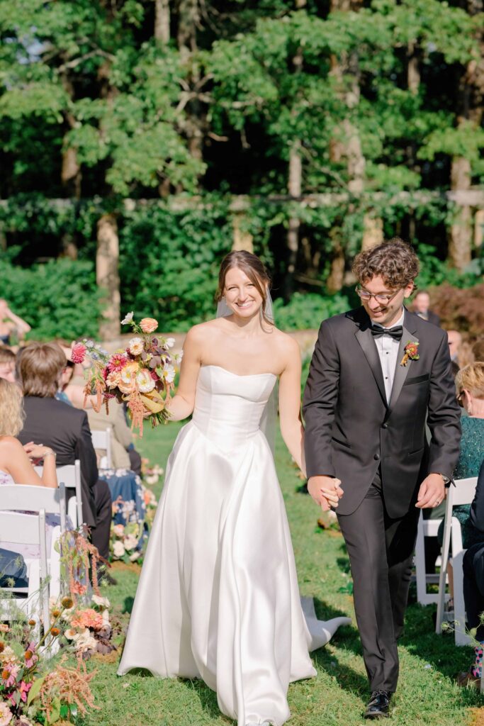 Ceremony seating on the lawn with vintage parasols and a mountain view backdrop
