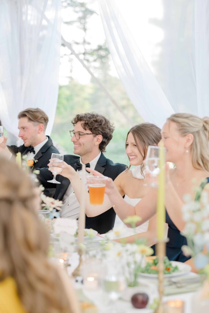 Groomsmen laughing and clinking glasses during cocktail hour