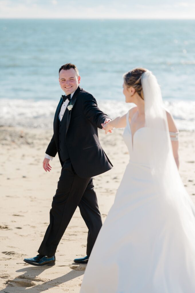Couple walking hand-in-hand along the shore outside Beauport Hotel in Gloucester Massachusett