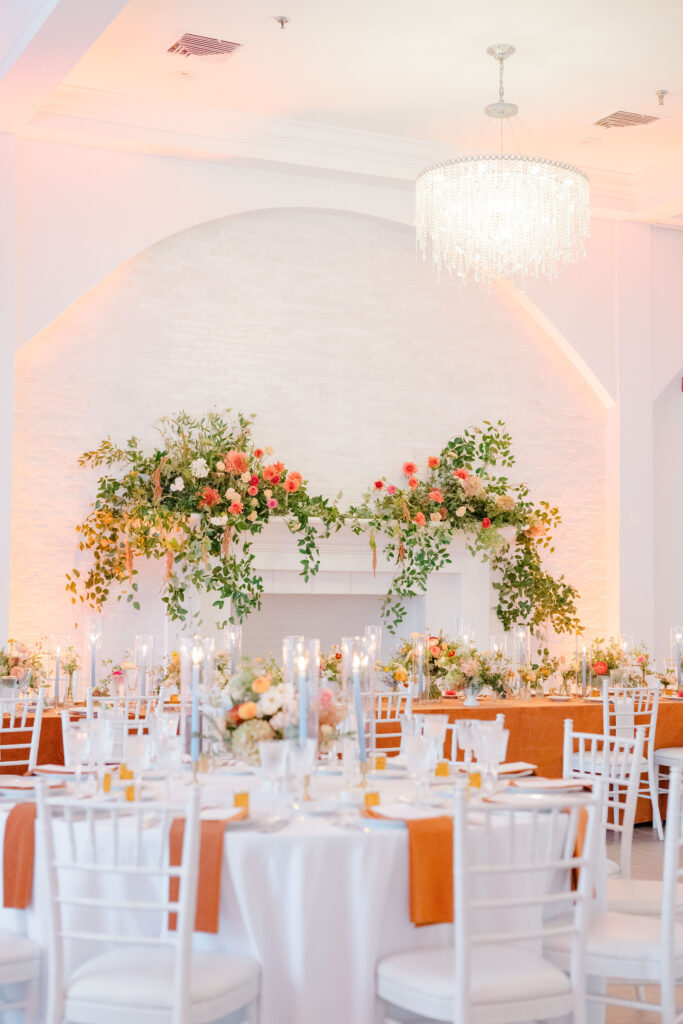 Floral-adorned fireplace at Belle Mer wedding reception with warm autumn-inspired decor.