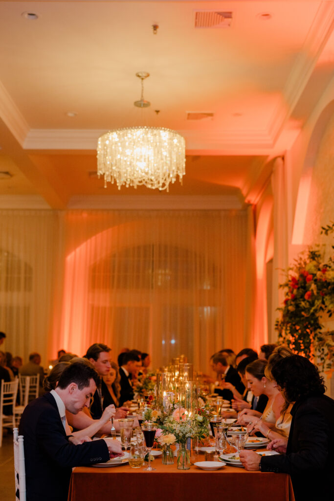 Wedding guests dining during Belle Mer wedding reception with warm evening lighting.