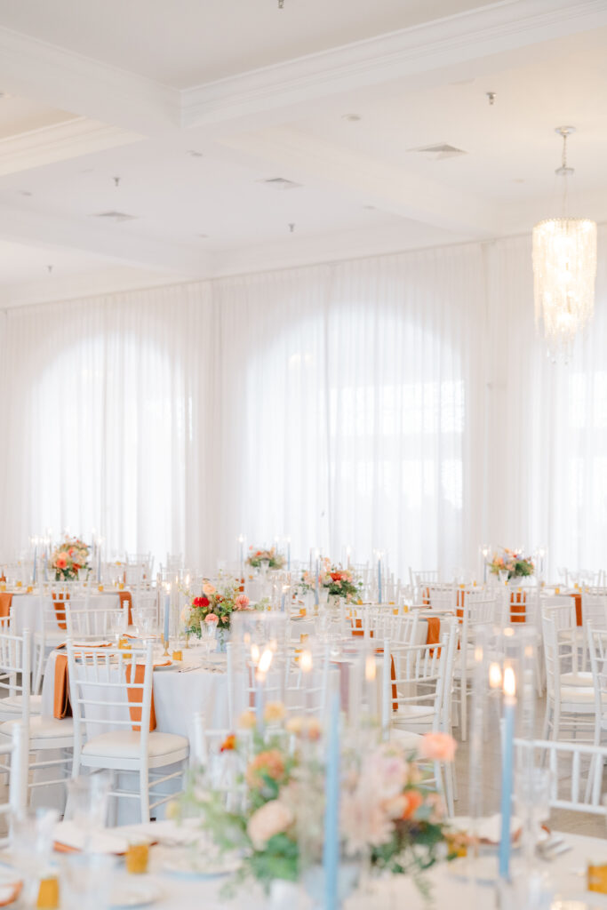 Wide view of Belle Mer wedding reception space with fall-inspired florals and elegant tablescape.