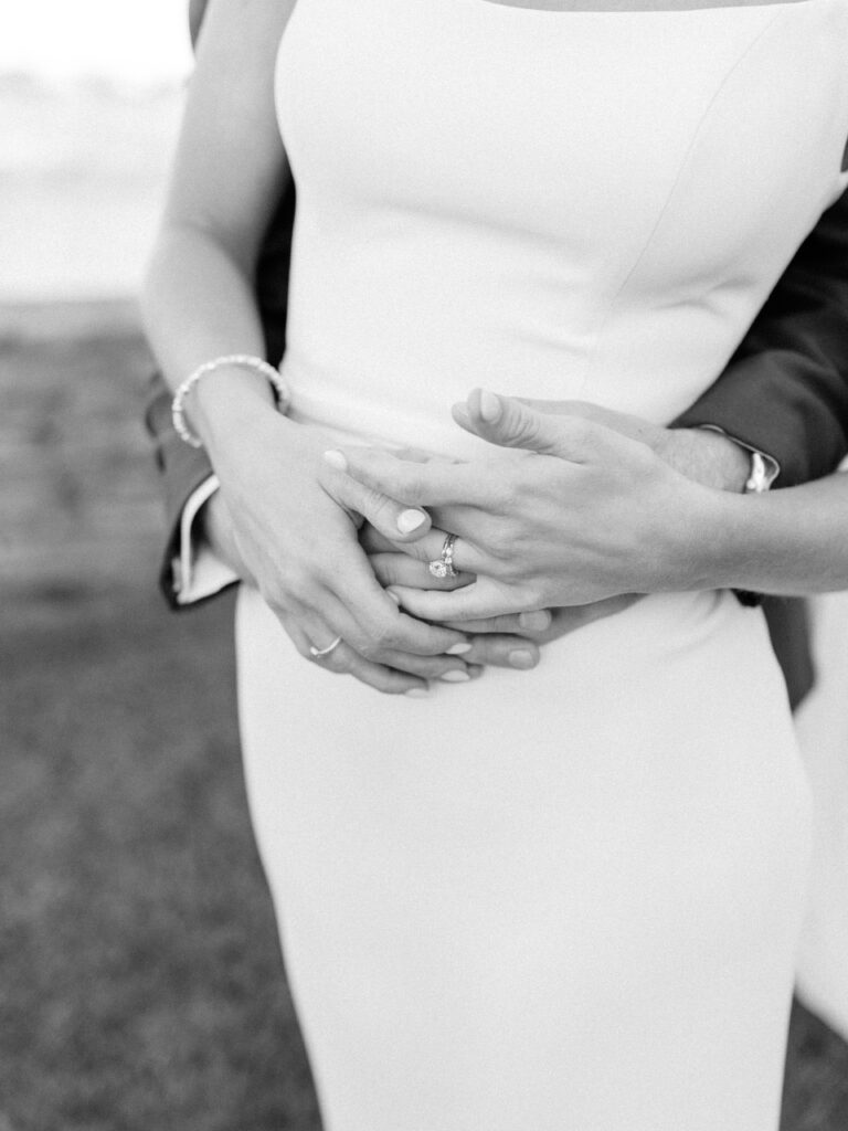Close-up of bride and groom holding hands with wedding rings at Wychmere Beach Club
