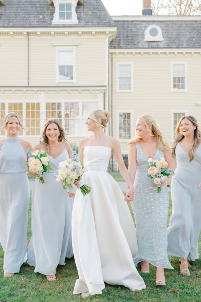 Bridesmaids in soft pastel dresses holding wildflower-inspired bouquets.