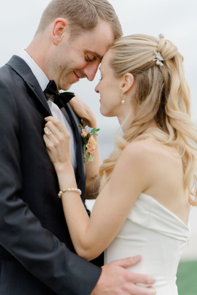Romantic close-up portrait of bride and groom embracing at Belle Mer wedding.