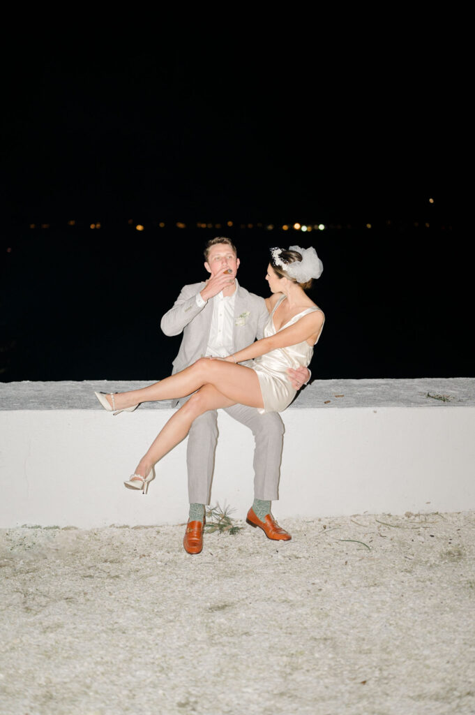 Bride and groom enjoying a late-night moment by the water at Belle Mer with Newport skyline lights in background.