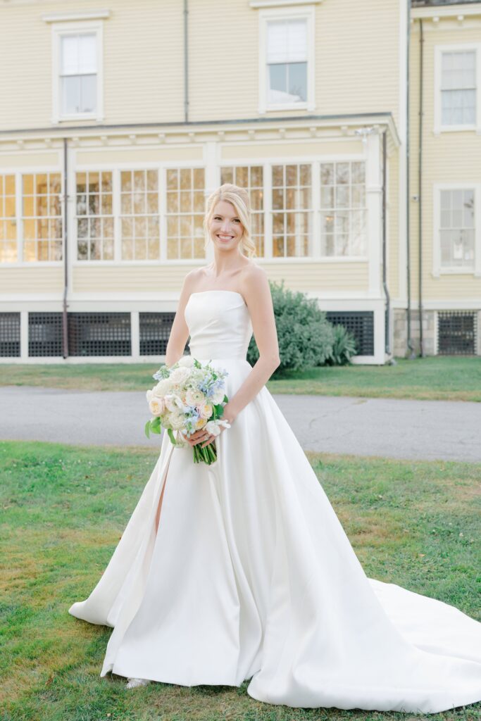 Bride holding bouquet of pastel wildflowers framed against the Eisenhower House architecture.