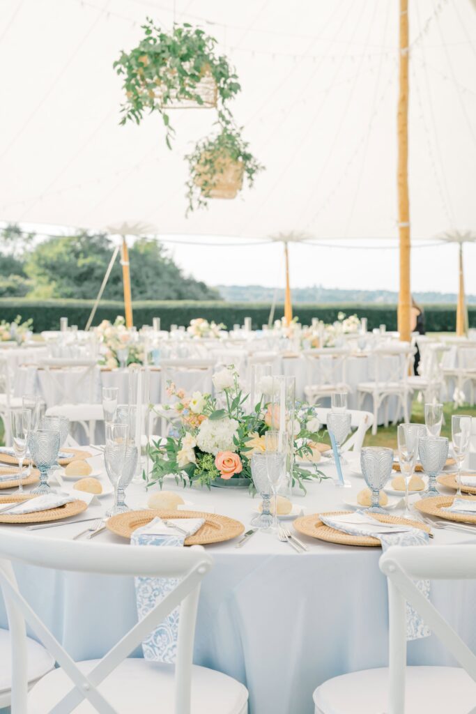 Coastal-inspired centerpiece with garden roses and dusty blue accents at a Newport wedding table.