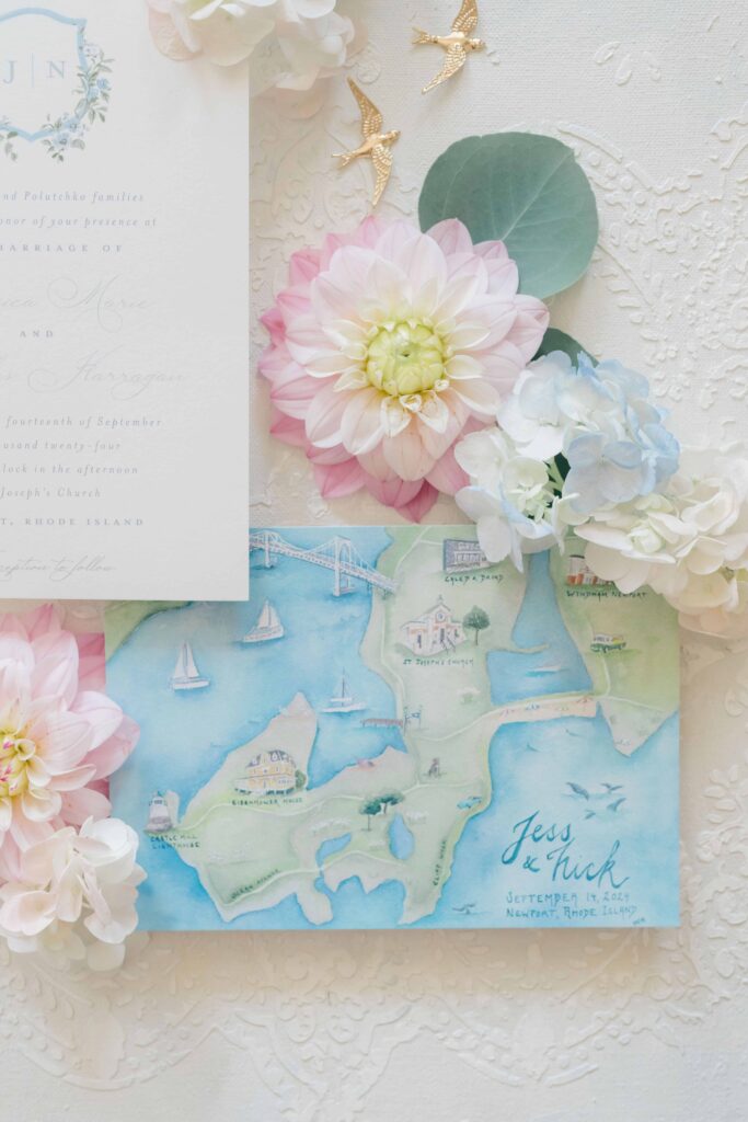 Flat lay of watercolor invitation suite and pearl-studded veil styled for a coastal wedding at Eisenhower House Newport Rhode Island.
