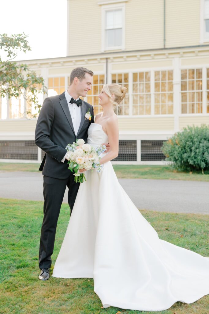 Romantic newlywed portraits with pastel florals and coastal breeze in Newport.