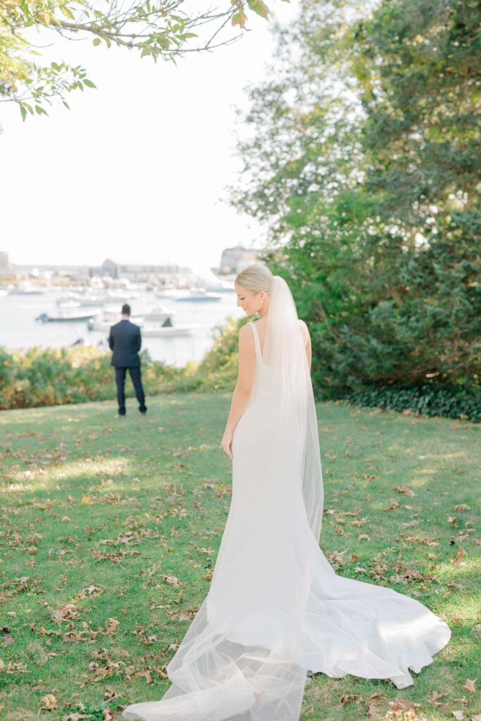 Bride approaching groom for waterfront first look at luxury Cape Cod wedding