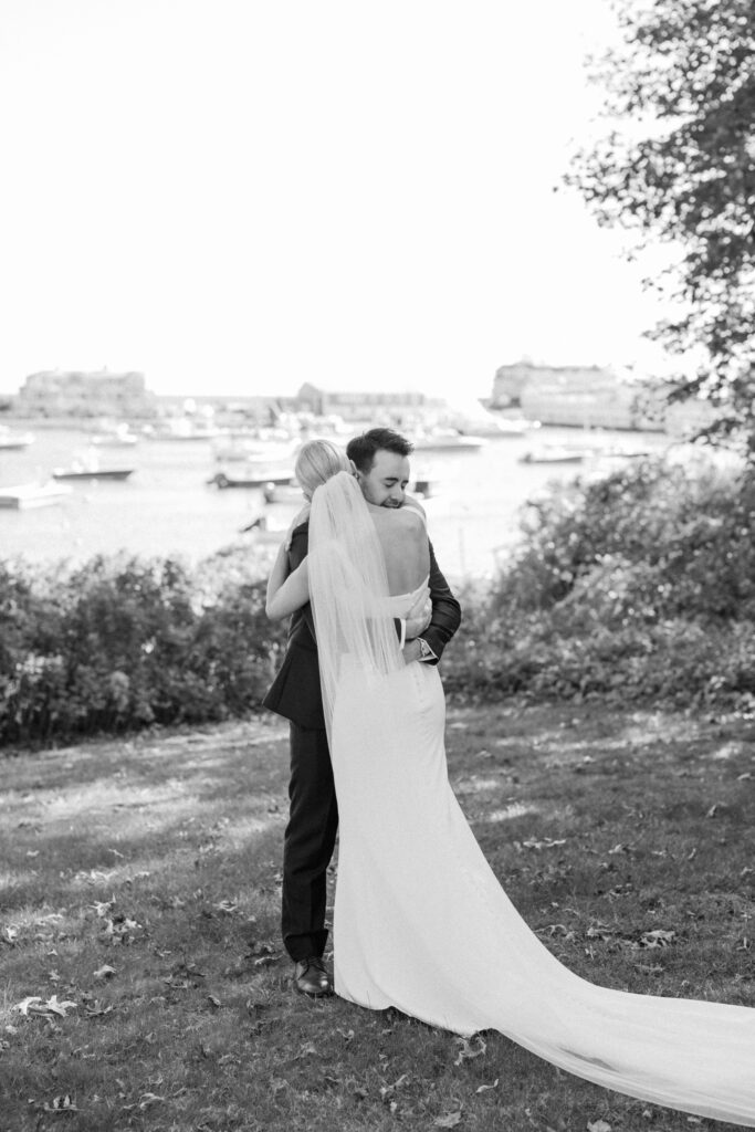 Bride and groom kissing near waterfront after first look at Wychmere Beach Club