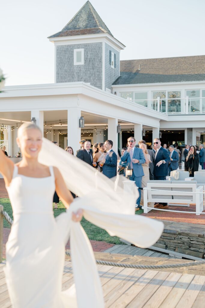 Bride twirling on Wychmere Beach Club dock during cocktail hour