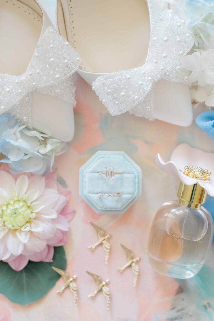 Soft bridal accessories styled with pastel florals and custom crest for a Newport wedding.