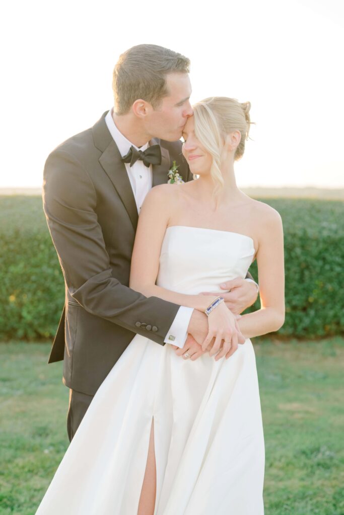 Newlyweds embracing during golden hour portraits on the lawn of Eisenhower House.