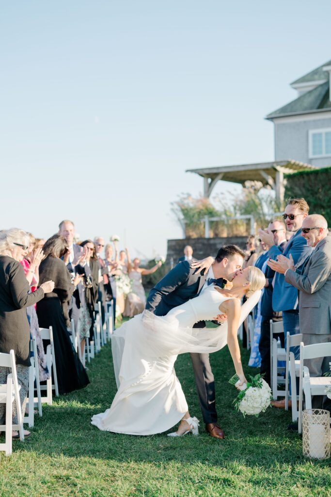 Bride and groom kissing during ceremony recessional at Wychmere Beach Club