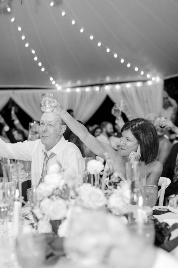 Guests toasting under string lights during sunset reception at Eisenhower House.