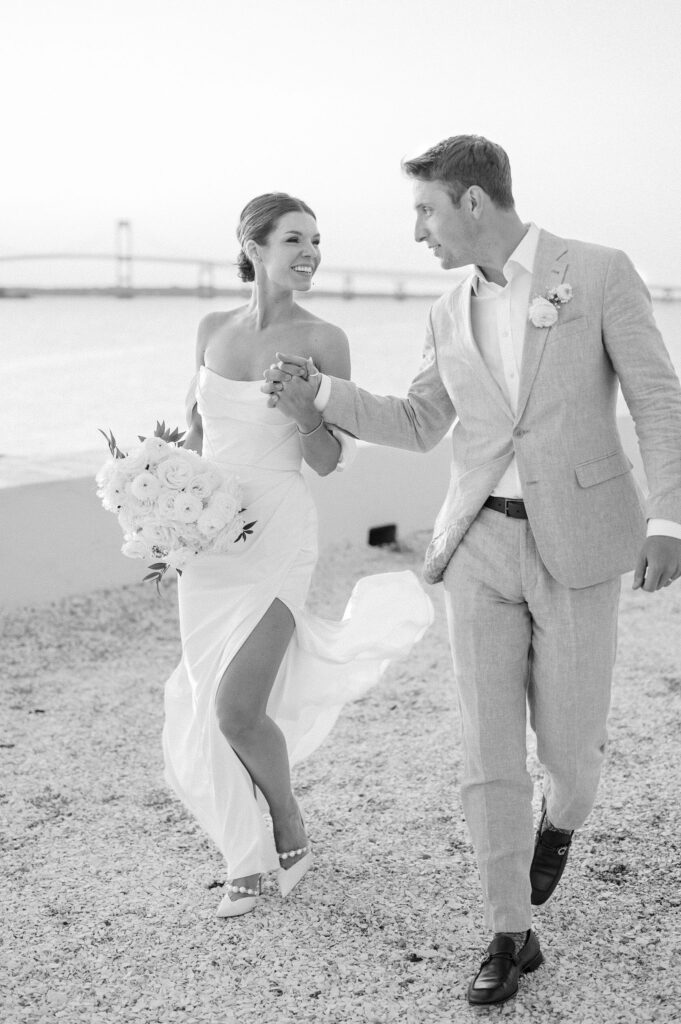 Joyful candid of bride and groom with wedding bouquet during golden hour portraits at Belle Mer.