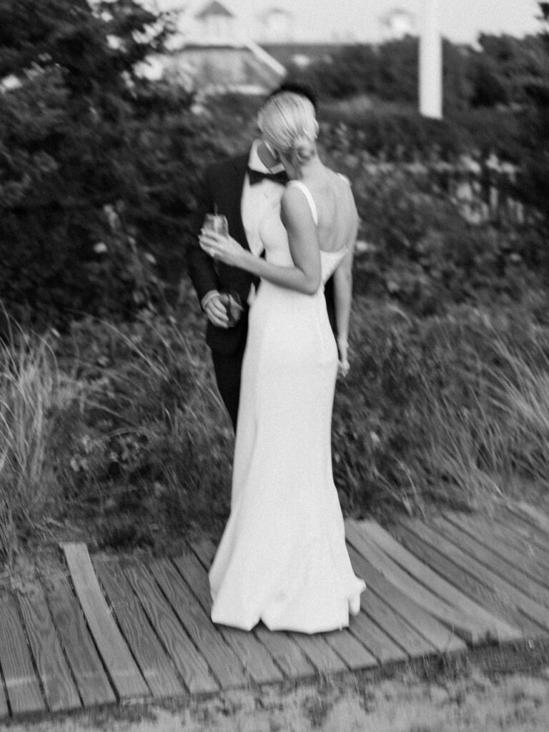 Intimate bride and groom champagne toast portrait on Cape Cod boardwalk